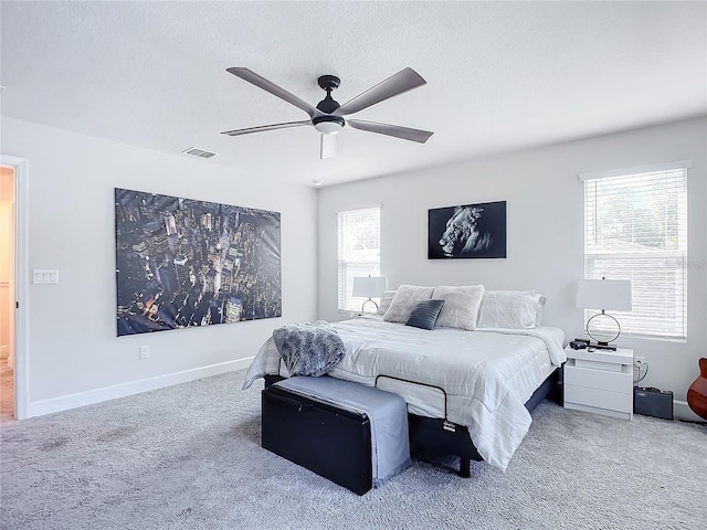 carpeted bedroom with ceiling fan, a textured ceiling, and multiple windows