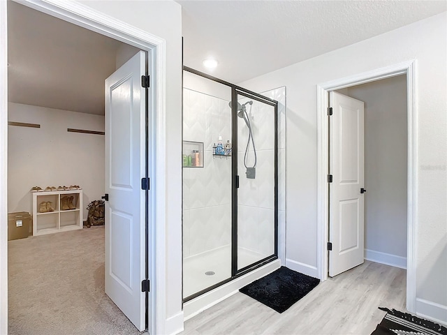 bathroom featuring wood-type flooring and a shower with door