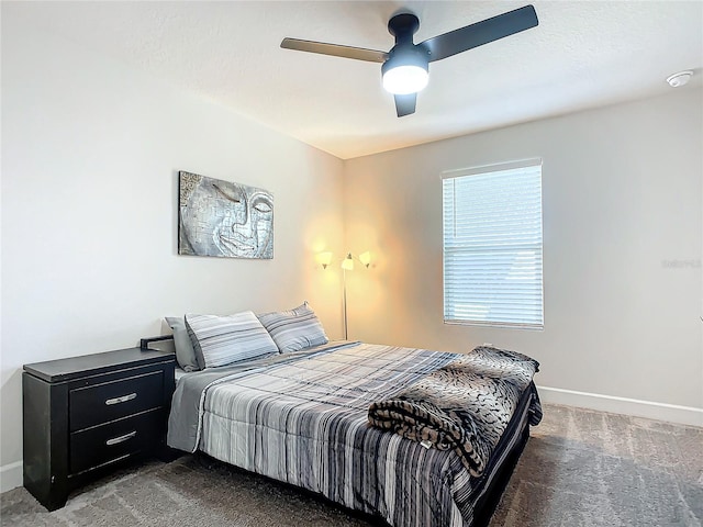 carpeted bedroom featuring ceiling fan and a textured ceiling