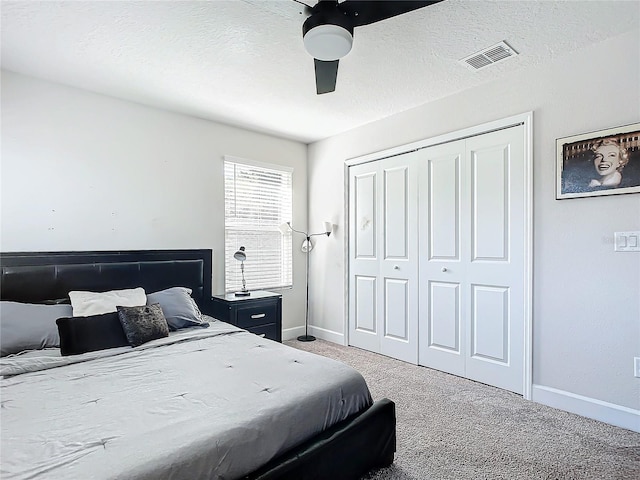 bedroom with carpet, a textured ceiling, a closet, and ceiling fan