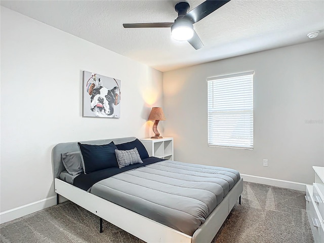 carpeted bedroom with ceiling fan and a textured ceiling