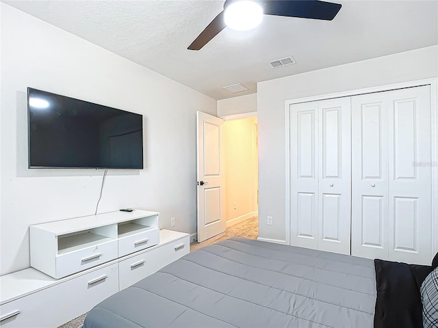 bedroom featuring ceiling fan, a closet, and a textured ceiling