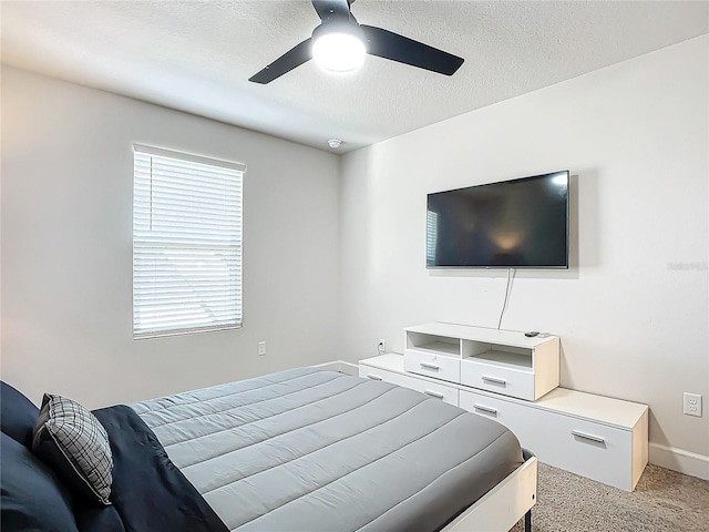 bedroom with a textured ceiling, carpet floors, and ceiling fan