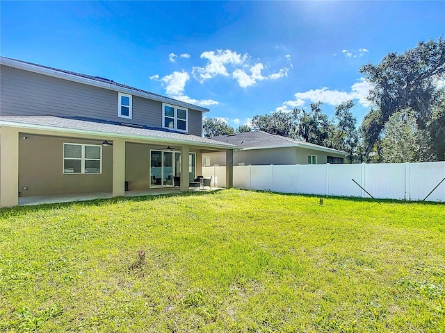 rear view of property featuring a patio area, ceiling fan, and a yard