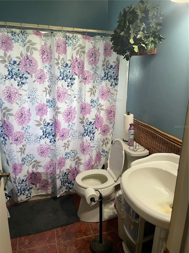 bathroom with walk in shower, tile patterned flooring, and toilet