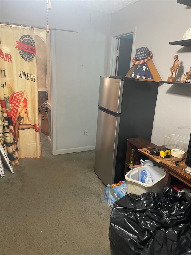 kitchen featuring carpet floors and stainless steel fridge