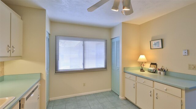 11 Andrea Dr, New Smyrna Beach, FL 32168 - kitchen with ceiling fan, white dishwasher, light tile patterned floors, baseboards, and white cabinetry