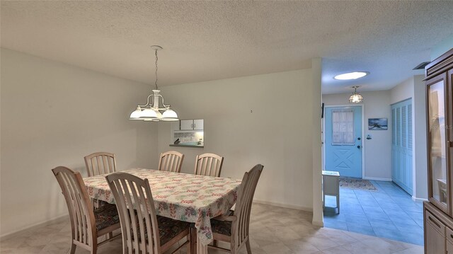 11 Andrea Dr, New Smyrna Beach, FL 32168 - dining room featuring a chandelier, a textured ceiling, baseboards, and light tile patterned floors