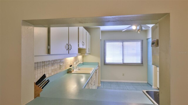 11 Andrea Dr, New Smyrna Beach, FL 32168 - kitchen with a sink, decorative backsplash, ceiling fan, white cabinetry, and light tile patterned floors