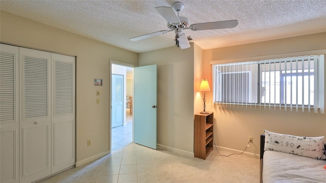 11 Andrea Dr, New Smyrna Beach, FL 32168 - bedroom with a closet, baseboards, a textured ceiling, ceiling fan, and light tile patterned floors