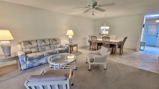 living room featuring light tile patterned floors, a textured ceiling, and ceiling fan