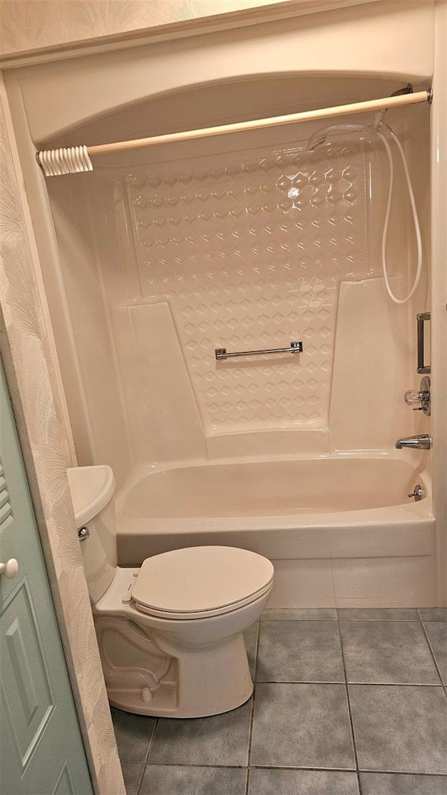 bathroom featuring tile patterned flooring, shower / bathtub combination, and toilet