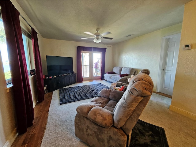 carpeted living room featuring a textured ceiling and ceiling fan