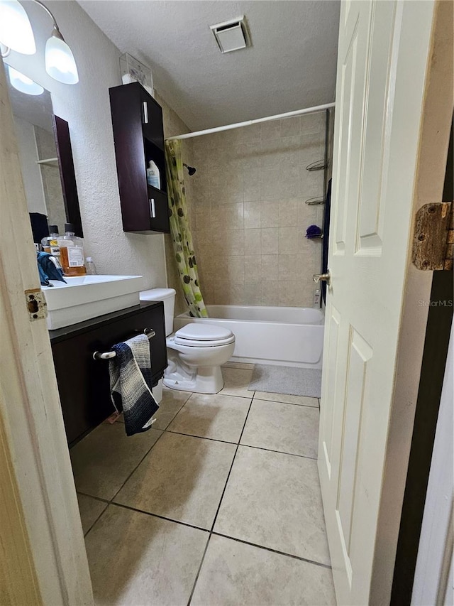 full bathroom with shower / tub combo, vanity, a textured ceiling, tile patterned flooring, and toilet