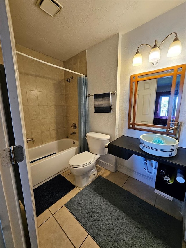 full bathroom featuring shower / bath combination with curtain, sink, a textured ceiling, tile patterned floors, and toilet