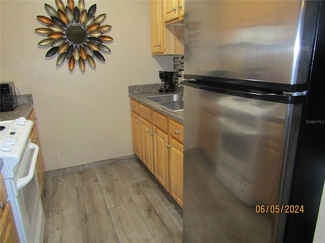 kitchen featuring light hardwood / wood-style flooring, sink, white range with electric stovetop, and stainless steel refrigerator