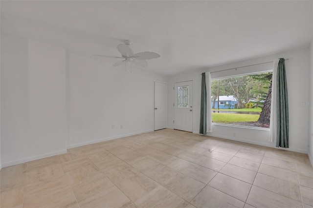 spare room with light tile patterned flooring and ceiling fan