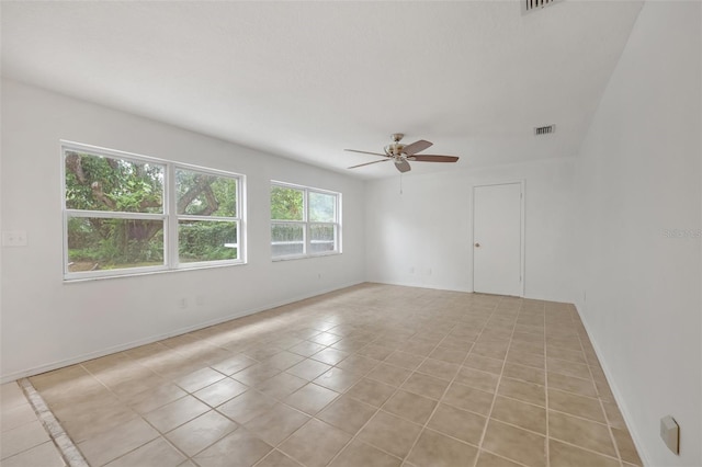 tiled spare room featuring ceiling fan