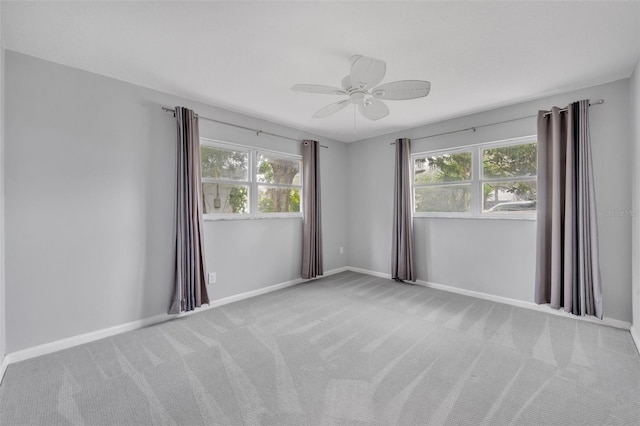 carpeted empty room with plenty of natural light and ceiling fan