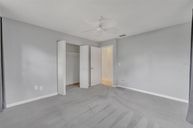 unfurnished bedroom with light colored carpet, a closet, and ceiling fan