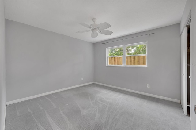 carpeted spare room featuring ceiling fan