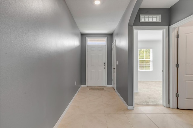 doorway to outside with light tile patterned flooring