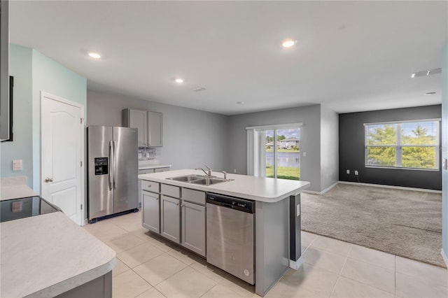 kitchen with an island with sink, appliances with stainless steel finishes, sink, and a wealth of natural light