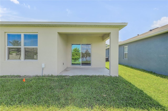 rear view of house featuring a patio and a lawn