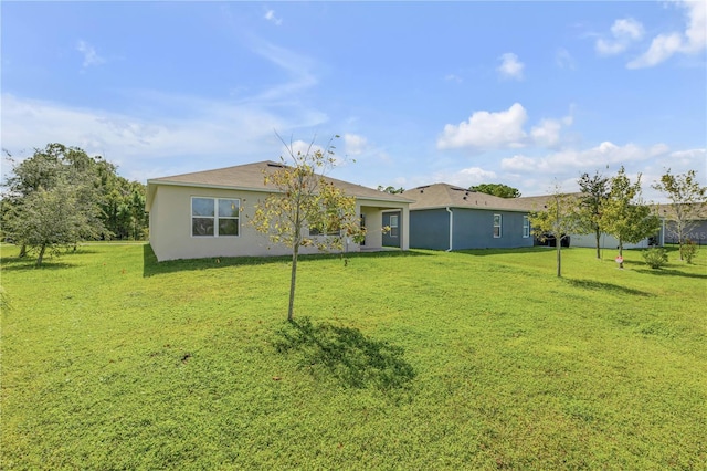 back of property featuring a lawn