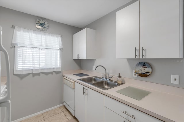 kitchen featuring white dishwasher, sink, light tile patterned floors, and white cabinetry