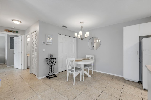 dining space featuring light tile patterned flooring and a notable chandelier