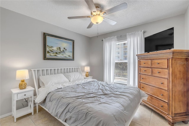 bedroom with ceiling fan, light tile patterned floors, and a textured ceiling