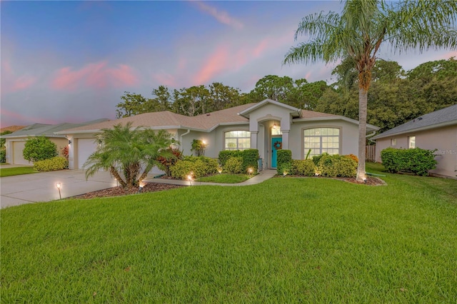 ranch-style house with a garage and a lawn