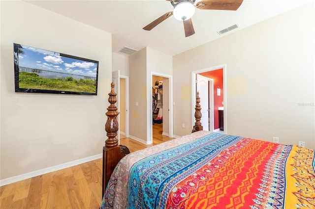 bedroom featuring a walk in closet, light hardwood / wood-style flooring, and ceiling fan