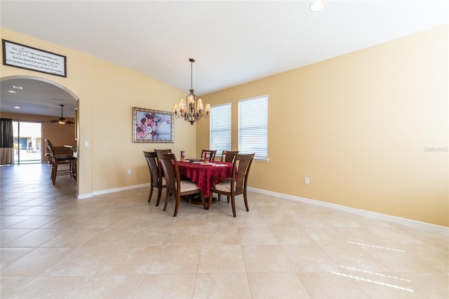 tiled dining room with ceiling fan with notable chandelier