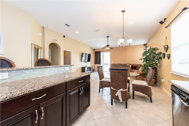 kitchen featuring dishwasher, ceiling fan with notable chandelier, decorative backsplash, light stone countertops, and decorative light fixtures