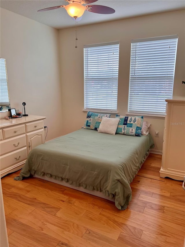 bedroom with light hardwood / wood-style flooring and ceiling fan