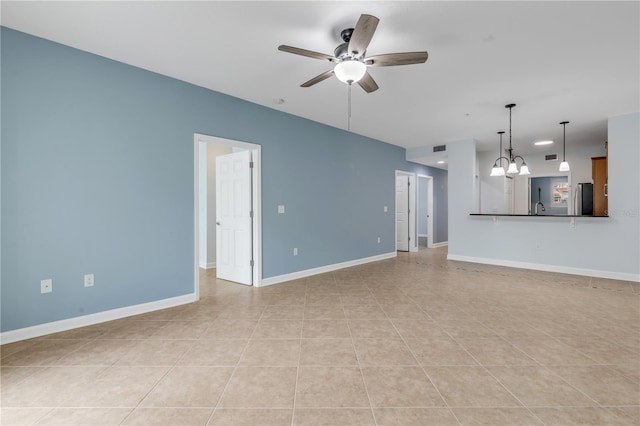 unfurnished living room featuring light tile patterned flooring and ceiling fan with notable chandelier