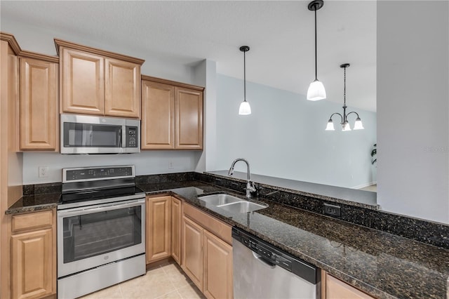 kitchen featuring light tile patterned flooring, pendant lighting, dark stone counters, sink, and stainless steel appliances