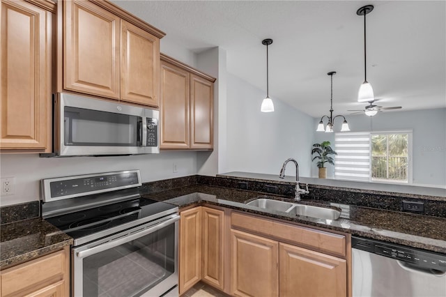 kitchen featuring pendant lighting, dark stone countertops, light brown cabinets, sink, and appliances with stainless steel finishes