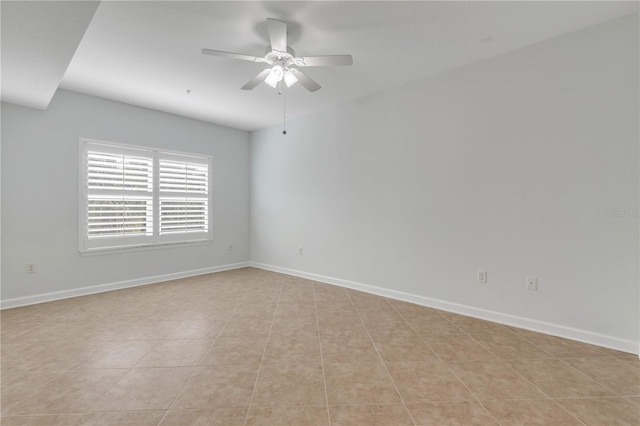 tiled spare room featuring ceiling fan