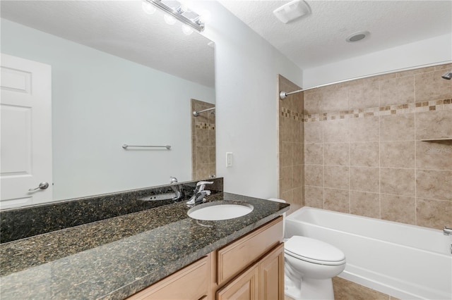 full bathroom with a textured ceiling, vanity, toilet, and tiled shower / bath combo