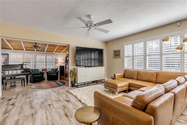 living room featuring a textured ceiling, plenty of natural light, and ceiling fan