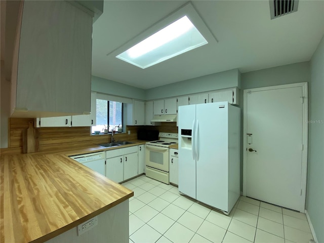 kitchen featuring light tile patterned floors, white cabinets, sink, and white appliances