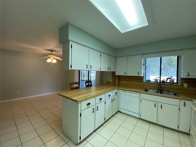 kitchen with kitchen peninsula, sink, white appliances, and white cabinetry