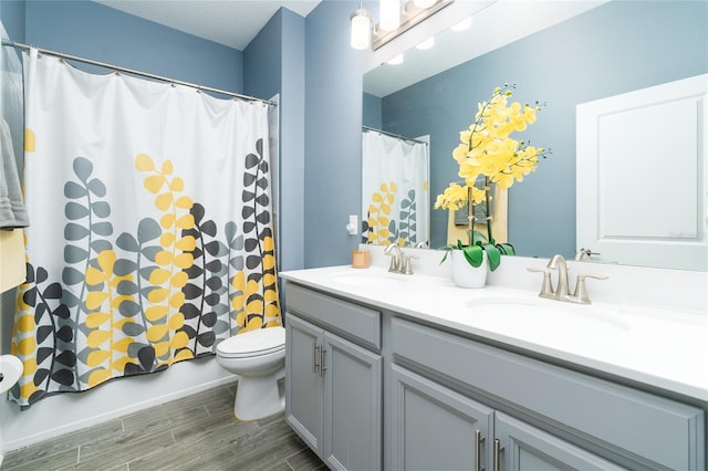 full bathroom with vanity, hardwood / wood-style floors, toilet, and shower / bathtub combination with curtain