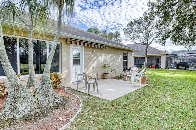 rear view of house featuring a yard, a patio area, and glass enclosure