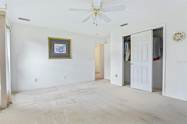 unfurnished bedroom featuring a closet, light colored carpet, and ceiling fan