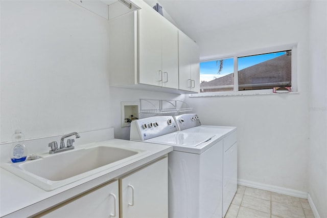 laundry area with sink, washing machine and dryer, light tile patterned floors, and cabinets