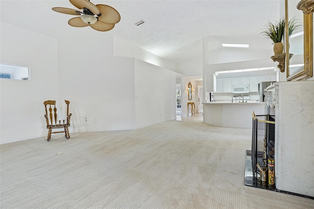 unfurnished living room featuring lofted ceiling, light colored carpet, and ceiling fan